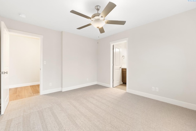 unfurnished bedroom featuring ensuite bath, light colored carpet, and ceiling fan