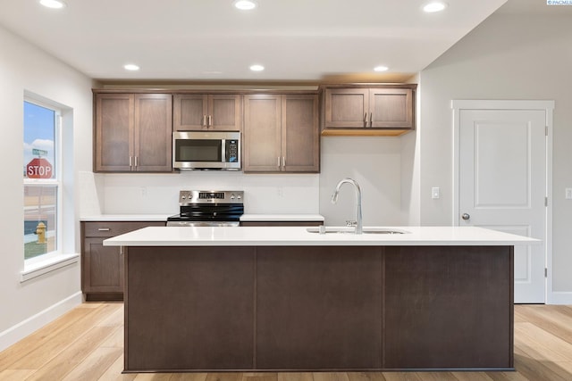 kitchen featuring sink, a wealth of natural light, a center island with sink, and appliances with stainless steel finishes