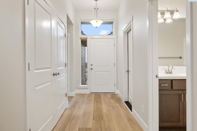 doorway with sink and light wood-type flooring