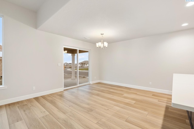 empty room with an inviting chandelier and light wood-type flooring