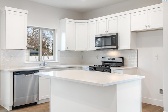 kitchen featuring light wood-type flooring, a sink, white cabinetry, and stainless steel appliances