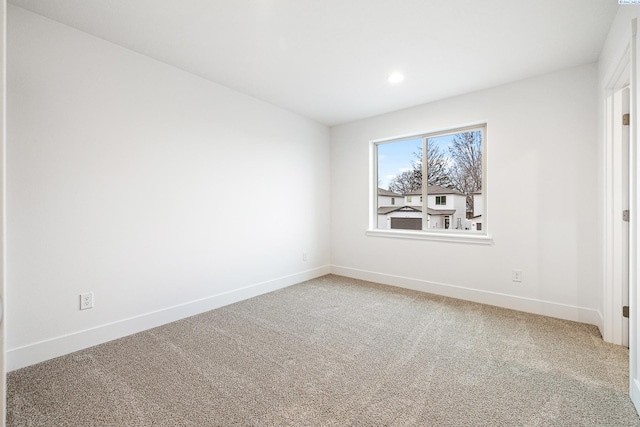 empty room featuring recessed lighting, baseboards, and carpet
