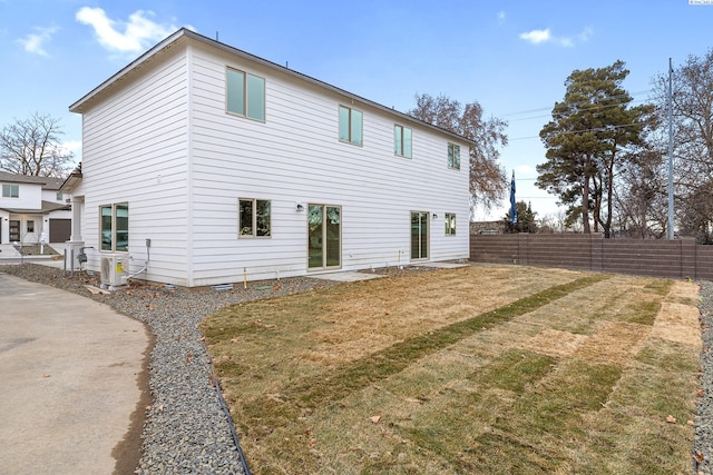 back of house with fence and a lawn