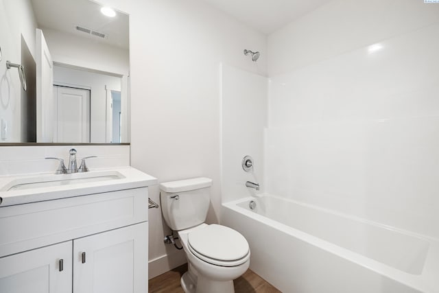 bathroom with visible vents, wood finished floors, vanity, toilet, and bathing tub / shower combination