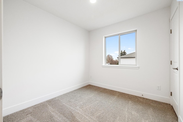 unfurnished room featuring carpet floors and baseboards