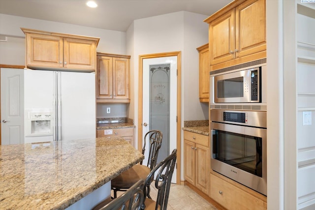 3610 S Johnson St, Kennewick, WA 99337 - kitchen with appliances with stainless steel finishes, light stone countertops, a breakfast bar area, recessed lighting, and light tile patterned floors