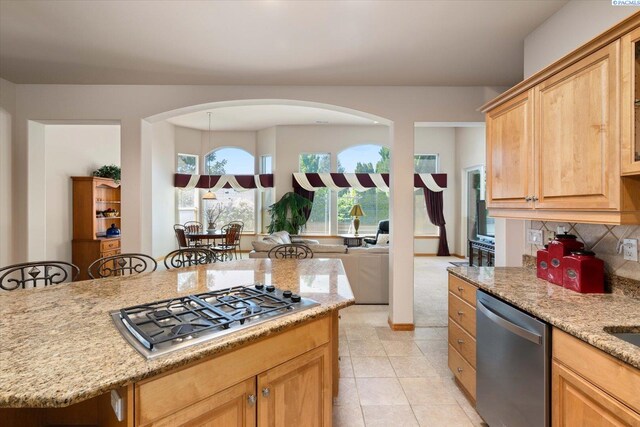 3610 S Johnson St, Kennewick, WA 99337 - kitchen featuring stainless steel appliances, light stone counters, light tile patterned floors, decorative backsplash, and arched walkways