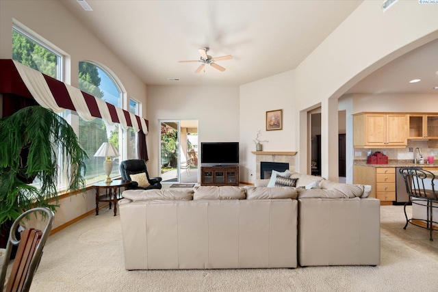 3610 S Johnson St, Kennewick, WA 99337 - living area featuring a ceiling fan, light carpet, arched walkways, a glass covered fireplace, and baseboards