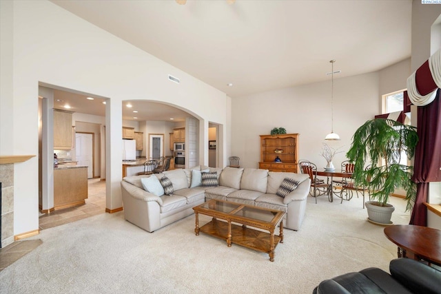 3610 S Johnson St, Kennewick, WA 99337 - living area featuring arched walkways, light colored carpet, a tile fireplace, recessed lighting, and lofted ceiling