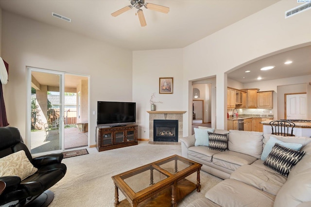 3610 S Johnson St, Kennewick, WA 99337 - living room featuring light colored carpet, a ceiling fan, a tiled fireplace, arched walkways, and recessed lighting