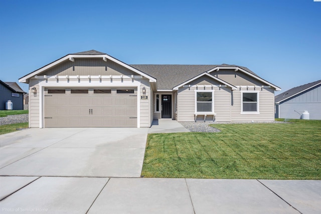 view of front of home with concrete driveway, a front lawn, an attached garage, and a shingled roof