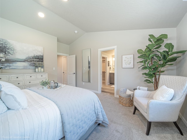 bedroom featuring lofted ceiling, recessed lighting, light colored carpet, baseboards, and ensuite bath