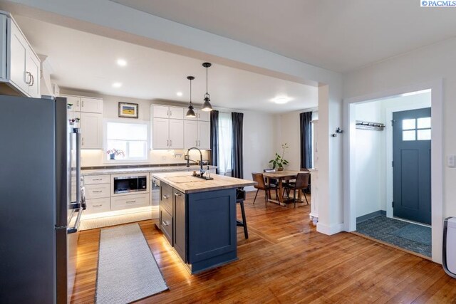 501 W California St, Garfield, WA 99130 - kitchen featuring stainless steel appliances, plenty of natural light, wood-type flooring, white cabinets, and recessed lighting