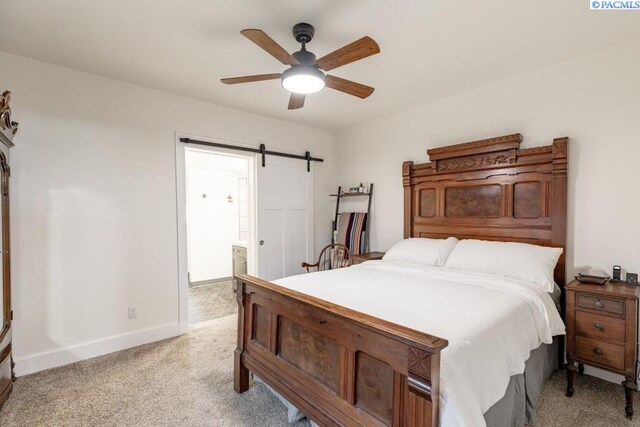 501 W California St, Garfield, WA 99130 - bedroom with light carpet, a barn door, baseboards, ensuite bath, and a ceiling fan