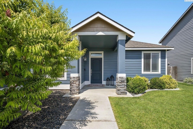 882 Pikes Peak Dr, West Richland, WA 99353 - doorway to property featuring roof with shingles and a yard