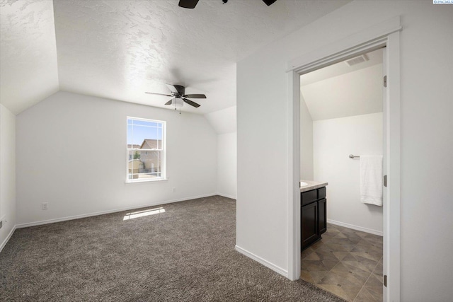 882 Pikes Peak Dr, West Richland, WA 99353 - additional living space with ceiling fan, vaulted ceiling, dark colored carpet, a textured ceiling, and baseboards