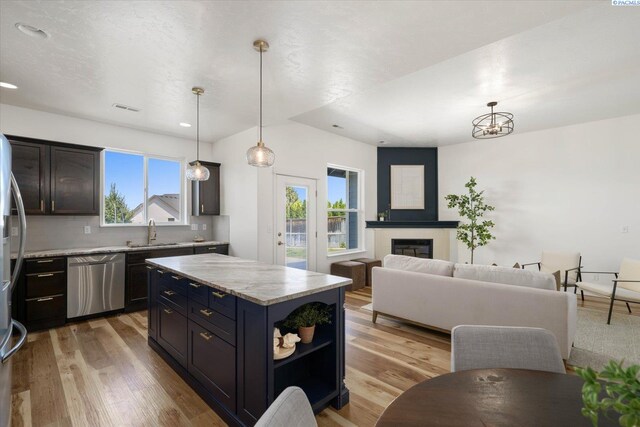 882 Pikes Peak Dr, West Richland, WA 99353 - kitchen with dishwasher, plenty of natural light, a glass covered fireplace, and light wood finished floors