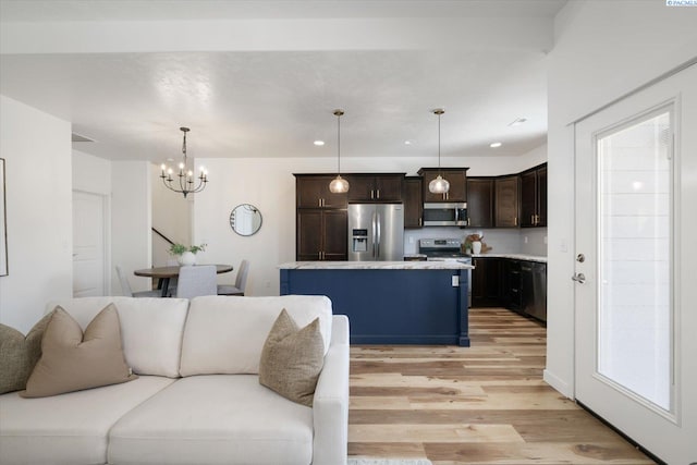 882 Pikes Peak Dr, West Richland, WA 99353 - kitchen featuring stainless steel appliances, a chandelier, open floor plan, light wood-type flooring, and dark brown cabinetry