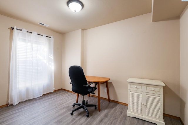 office space featuring light wood-style flooring, visible vents, and baseboards