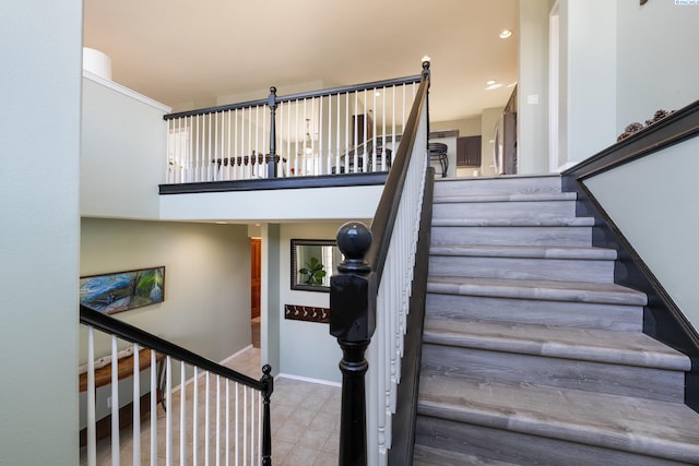 staircase with recessed lighting, tile patterned floors, a towering ceiling, and baseboards