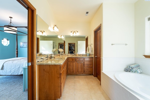 ensuite bathroom featuring a garden tub, tile patterned flooring, a notable chandelier, connected bathroom, and vanity