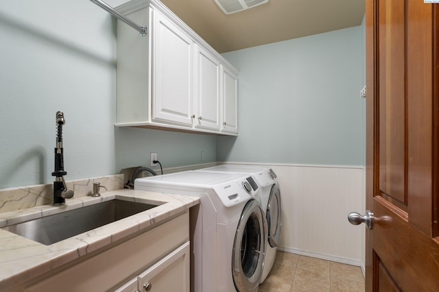 washroom with washing machine and dryer, a sink, visible vents, wainscoting, and cabinet space