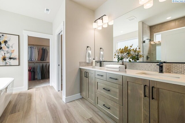12110 Dunsmuir Dr, Pasco, WA 99301 - full bath featuring double vanity, wood finished floors, backsplash, and a spacious closet