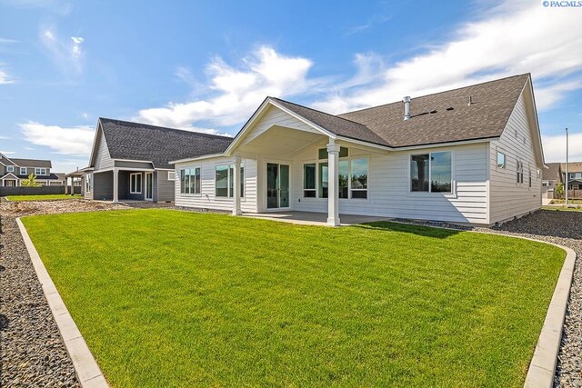 12110 Dunsmuir Dr, Pasco, WA 99301 - rear view of property featuring a shingled roof, a lawn, and a patio area