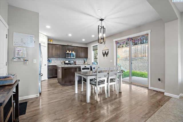 dining space featuring baseboards, dark wood finished floors, and recessed lighting