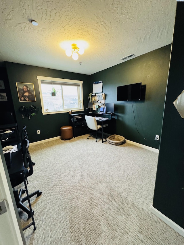 carpeted office featuring visible vents, a textured ceiling, and baseboards