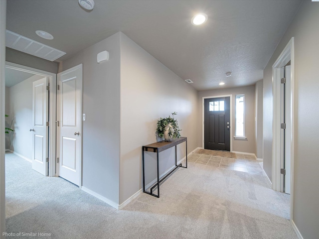 foyer entrance featuring recessed lighting, carpet flooring, and baseboards