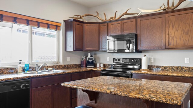 5801 Thistledown Dr, Pasco, WA 99301 - kitchen with black appliances, a sink, a kitchen breakfast bar, a center island, and dark stone countertops