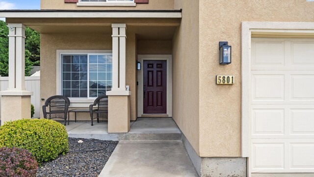 5801 Thistledown Dr, Pasco, WA 99301 - entrance to property featuring stucco siding, covered porch, and a garage