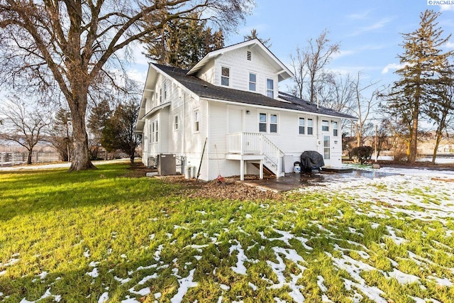 snow covered house featuring a lawn