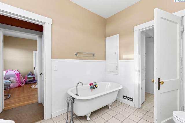 bathroom with tile patterned floors and a tub to relax in