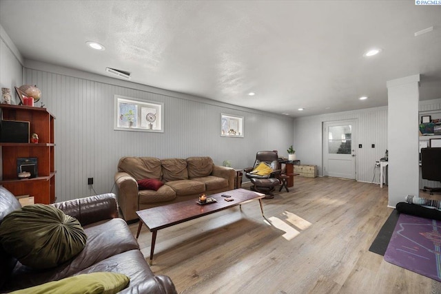 living room with visible vents, recessed lighting, and wood finished floors