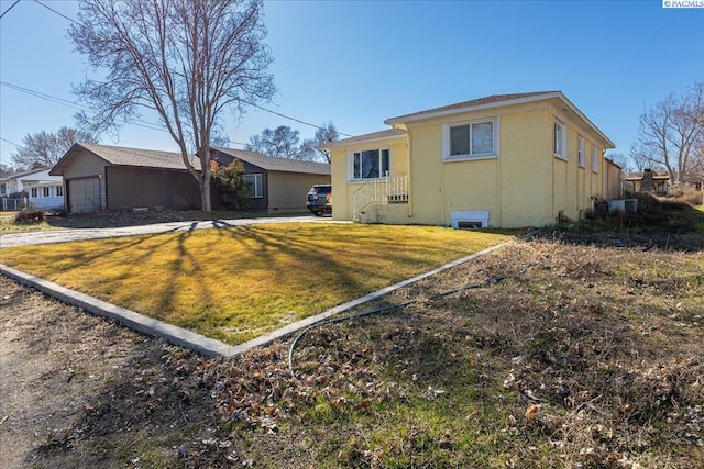 back of property with a yard and stucco siding