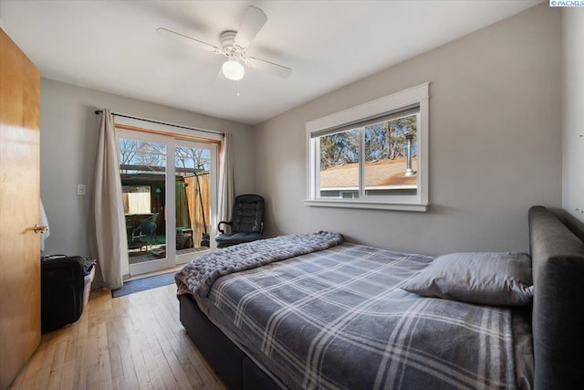 bedroom with access to outside, hardwood / wood-style floors, and a ceiling fan