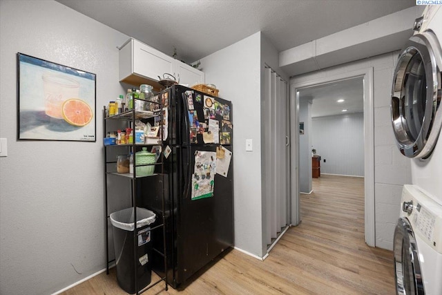 interior space featuring light wood-style flooring, stacked washer / dryer, laundry area, and baseboards