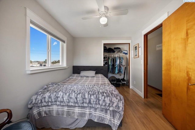 bedroom with ceiling fan, a closet, baseboards, and wood finished floors