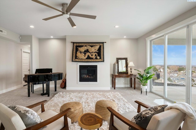 living area with recessed lighting, baseboards, a glass covered fireplace, and light colored carpet