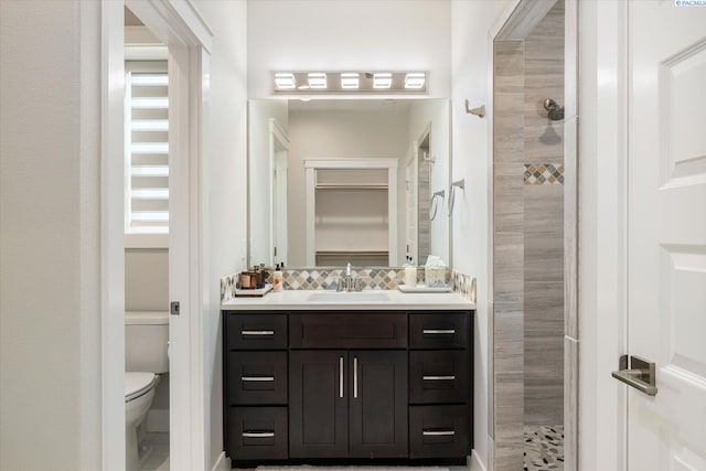 full bathroom featuring a walk in shower, vanity, toilet, and decorative backsplash