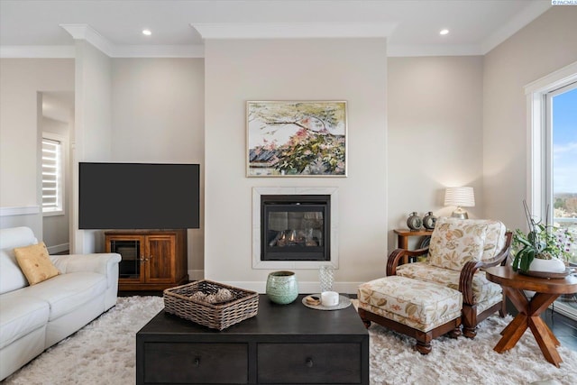 living room featuring ornamental molding, a glass covered fireplace, baseboards, and recessed lighting