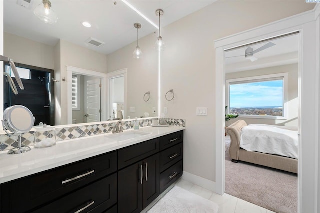 bathroom featuring baseboards, visible vents, vanity, and ensuite bath