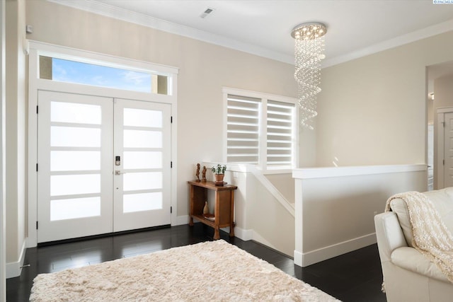 entryway with baseboards, dark wood-style floors, crown molding, french doors, and a chandelier