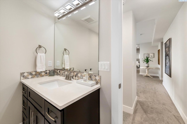 bathroom featuring visible vents, baseboards, and vanity