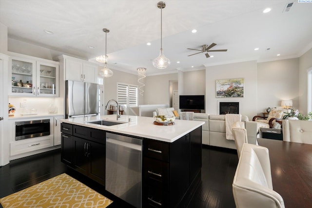 kitchen with dark cabinetry, appliances with stainless steel finishes, light countertops, and a sink