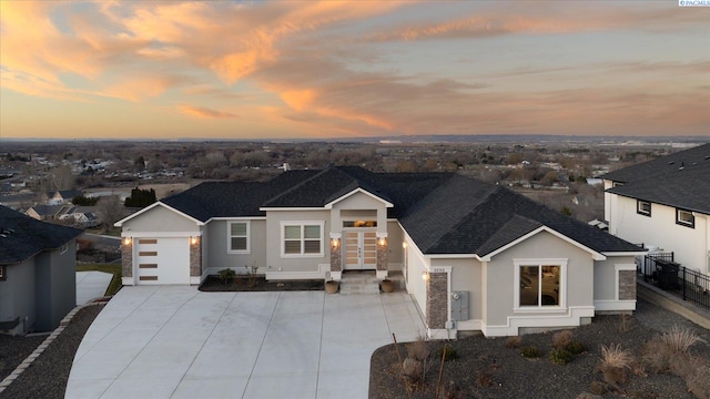 view of front of house with a garage, roof with shingles, and stucco siding