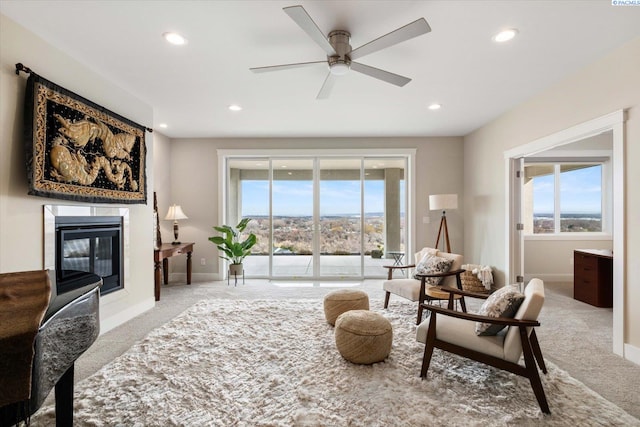 carpeted living area featuring a glass covered fireplace, plenty of natural light, baseboards, and recessed lighting