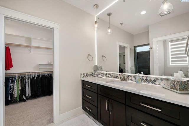 full bathroom featuring a shower stall, a spacious closet, visible vents, and vanity